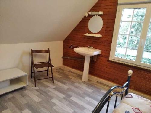 une salle de bain avec un lavabo, un miroir et une chaise dans l'établissement Villa Les Bosquets, à Fort-Mahon-Plage