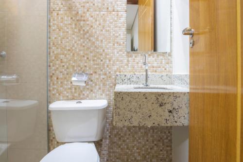 a bathroom with a toilet and a sink at OYO Tropical Confort Hotel, Brasilia in Brasilia