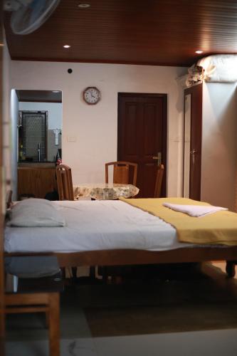 ein Schlafzimmer mit einem Bett und einer Uhr an der Wand in der Unterkunft Dreams Valley in Kadavoor