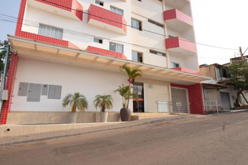 a building with palm trees in front of it at OYO Tropical Confort Hotel, Brasilia in Brasilia