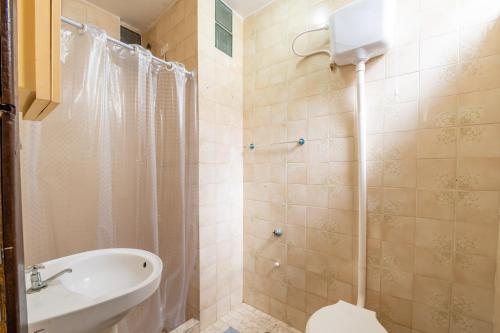 a bathroom with a shower and a toilet and a sink at OYO Residencial Muriqui Apart Hotel, Mangaratiba in Vila Muriqui