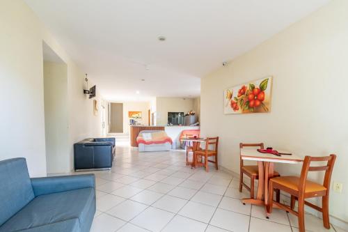 a living room with a couch and a table and chairs at OYO Residencial Muriqui Apart Hotel, Mangaratiba in Vila Muriqui
