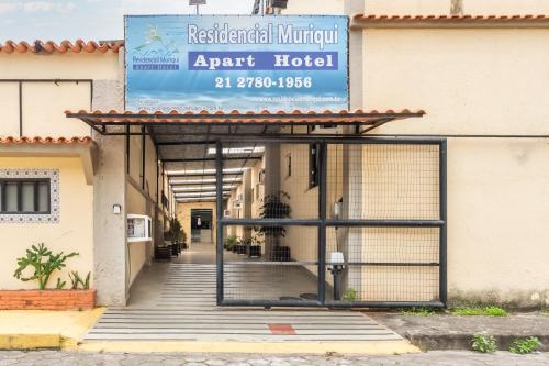 an entrance to an apartment building with a sign on it at OYO Residencial Muriqui Apart Hotel, Mangaratiba in Vila Muriqui
