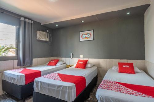 two beds in a room with red pillows on them at OYO Nações Unidas, Sao Paulo in Sao Paulo