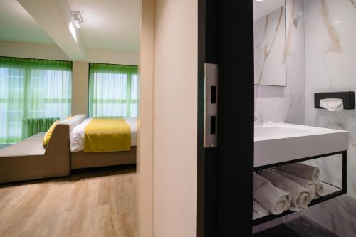 a bathroom with a bed and a sink and a tub at Ostend Hotel in Ostend