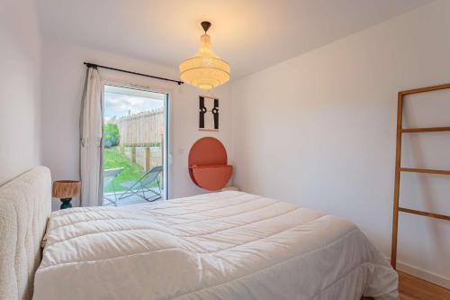 une chambre avec un lit blanc et une fenêtre dans l'établissement Appartement décoré avec gout proche des plages d'Anglet, à Anglet