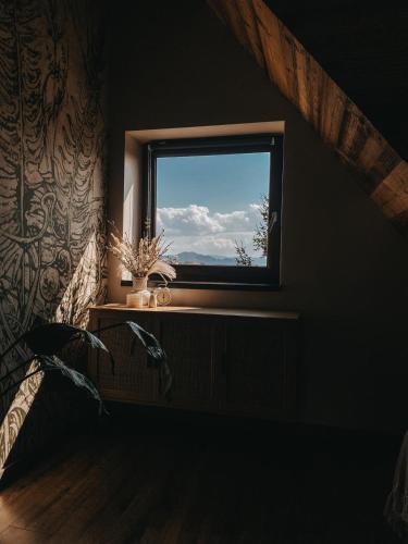 a window in a room with a plant on a table at Okno w Gorce-magiczny apartament na uboczu nad jeziorem Czorsztyńskim, Velo Czorsztyn, Szczawnica, Zakopane in Maniowy