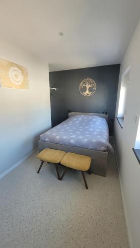 a small bedroom with a bed and a bench at Au pied de la Basilique de Saint Nicolas de port in Saint-Nicolas-de-Port