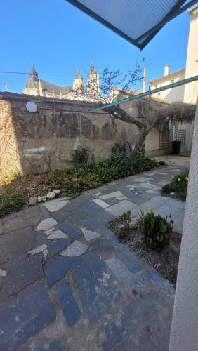 a stone walkway next to a building with a wall at Au pied de la Basilique de Saint Nicolas de port in Saint-Nicolas-de-Port