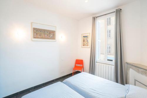 une chambre avec un lit et une chaise rouge dans l'établissement Bright and modern 2 BR in the heart of Antibes!, à Antibes