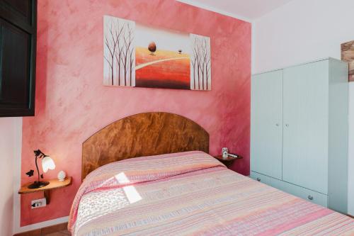 una camera da letto con un letto e una parete rosa di Casa Chiocciola a San Vito lo Capo