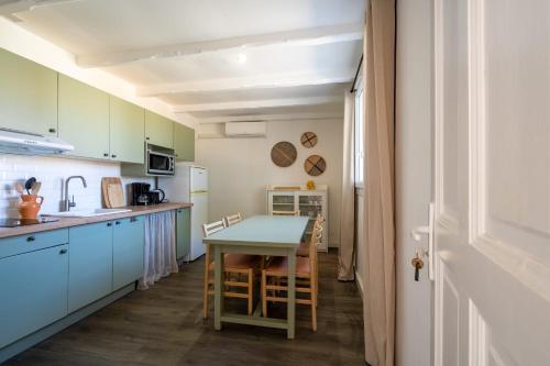 une cuisine avec une table et des chaises dans une pièce dans l'établissement Provençal stone T3 cottage in a tourist residence, à La Roque-sur-Pernes