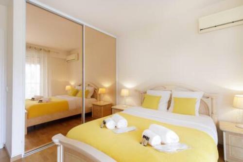 une chambre avec deux lits et un grand miroir dans l'établissement Le Volta - 1 bedroom appartment with AC, à Cannes