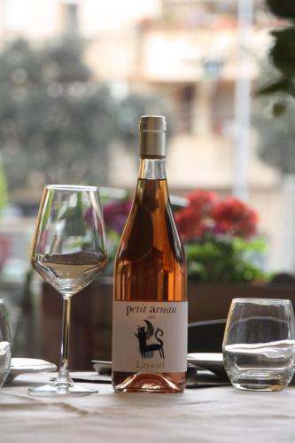 a bottle of wine sitting next to a wine glass at Hostal Crisami in Solsona