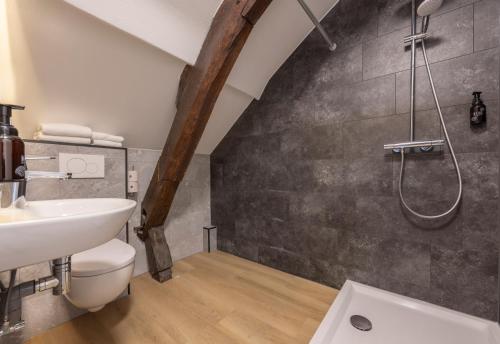 a bathroom with a shower and a toilet and a sink at Fletcher Hotel Restaurant De Burghoeve in Valkenburg