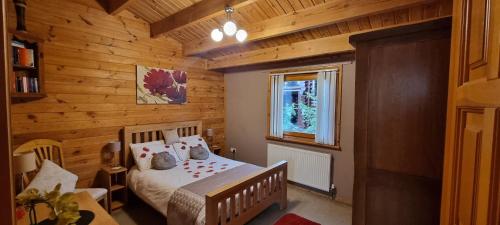 a bedroom with a bed in a wooden cabin at Elite Retreats 4U Lakeside Hot Tub Log Cabin at Tattershall Lakes Park in Tattershall