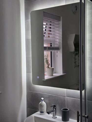 a bathroom with a sink with a mirror and a sink at Perfect home from home, Heart of Belfast Sleeps 6 in Belfast