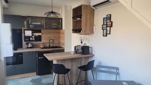 a kitchen with a counter and some chairs in it at Au pied de la Basilique de Saint Nicolas de port in Saint-Nicolas-de-Port