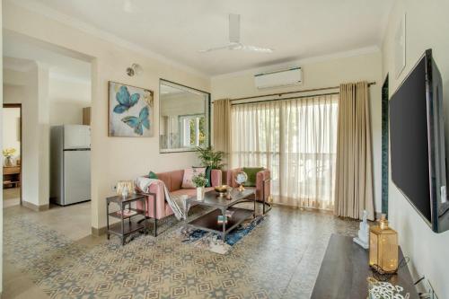 a living room with a couch and a table at IVAAN Stays in Assagao