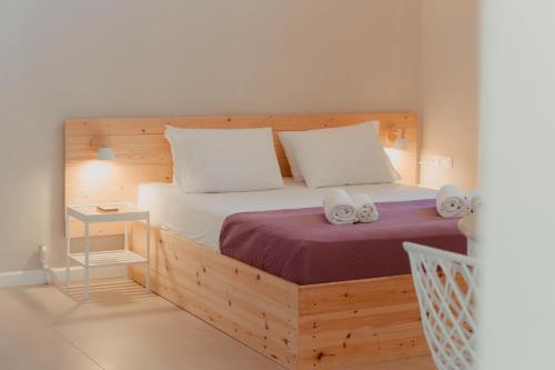 ein Schlafzimmer mit einem Holzbett mit zwei weißen Kissen in der Unterkunft Coastal Cottage Chic House in Vlikhón