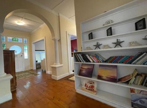 una sala de estar con estanterías blancas llenas de libros en 33 on Smuts Selborne, en East London
