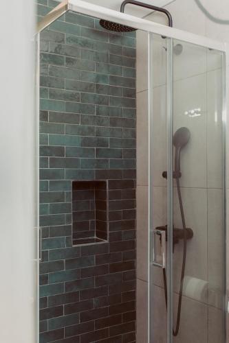 a bathroom with a shower with a glass door at Coastal Cottage Chic House in Vlikhón