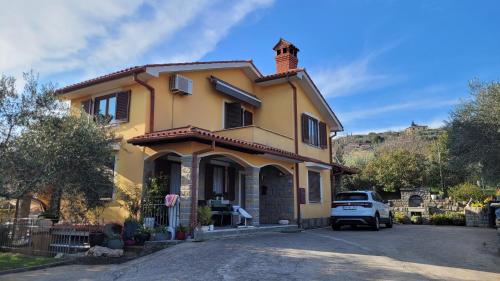 a yellow house with a car parked in the driveway at Mar Apartments in Portorož