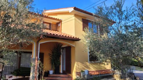 a yellow house with trees in front of it at Mar Apartments in Portorož