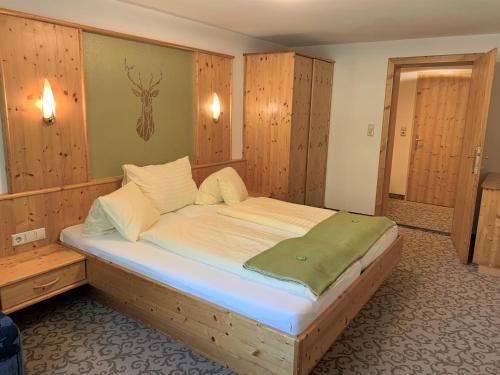 a large bed in a room with wooden walls at Heisshof in Schladming