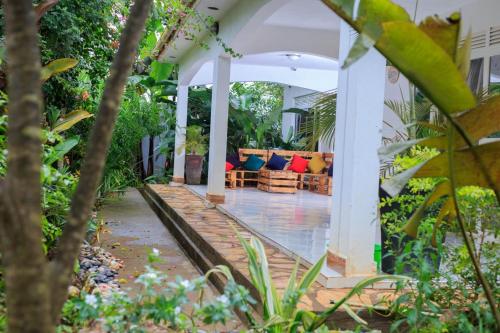 an outdoor living room with a couch on a porch at White Guest House -Kakiri in Kampala