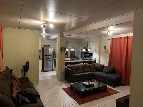 Spacious 4-Bedroom Family Home في باراماريبو: غرفة معيشة بها أريكة وطاولة