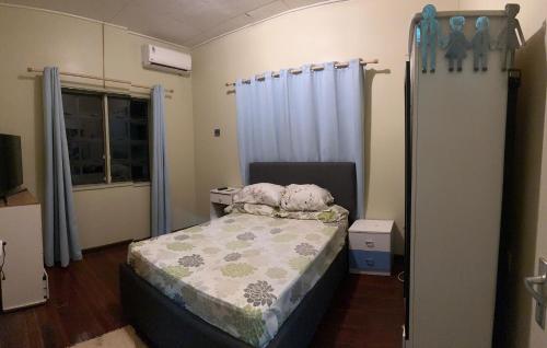 Spacious 4-Bedroom Family Home في باراماريبو: غرفة نوم صغيرة بها سرير ونافذة