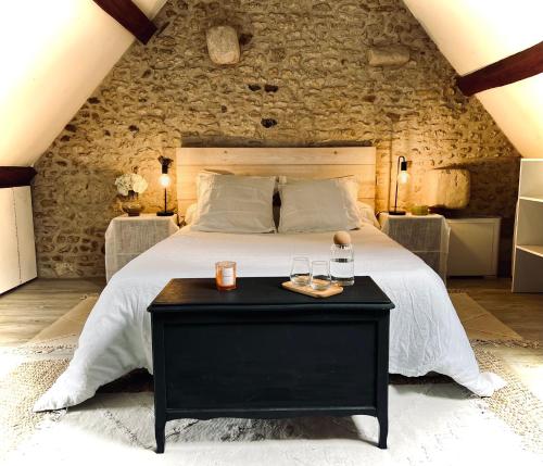 a bedroom with a large bed with a black table at Le Cottage des Chalands in Saint-Georges-sur-Cher