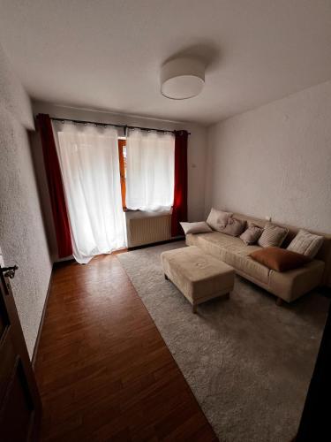 a living room with a couch and a large window at Haus Auszeit in Buchau