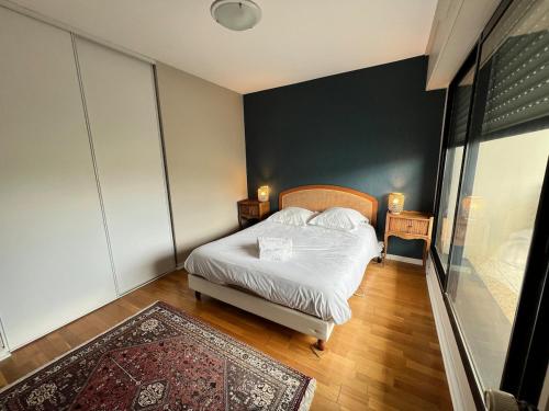 - une chambre avec un lit et un mur noir dans l'établissement Carnac joli appartement entre plage et ville!, à Carnac