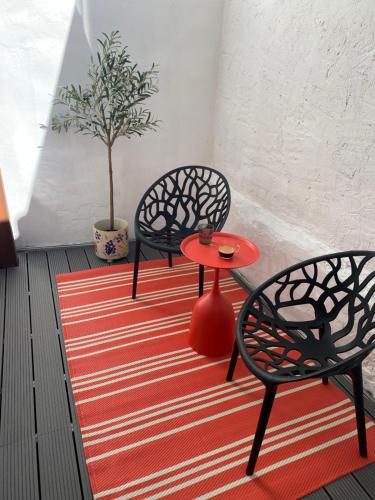 two chairs and a red table on a red rug at Marktplatz-Suite in Weinheim