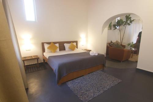 Vera Dune في كاندوليم: غرفة نوم عليها سرير ومخدات صفراء