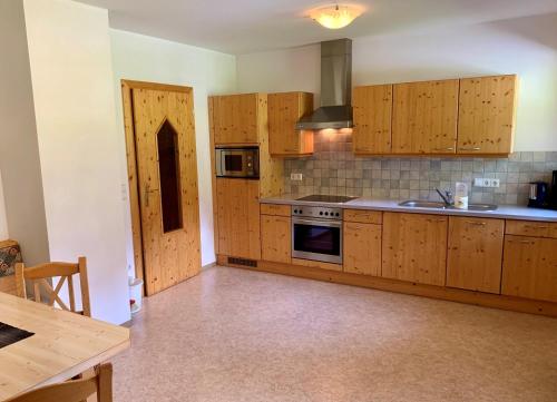 a kitchen with wooden cabinets and a stove top oven at Heisshof in Schladming