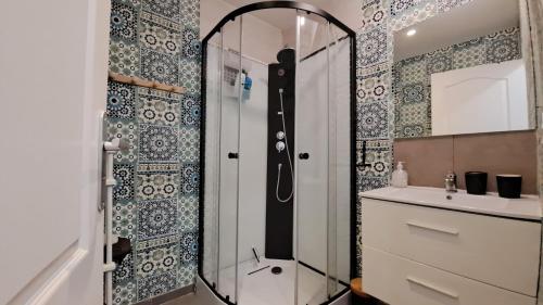une salle de bain avec une douche, un lavabo et un miroir dans l'établissement entre plage et rempart, à Boulogne-sur-Mer