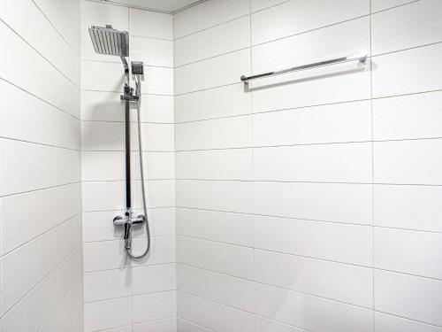 a white shower with a shower head at Chic Urban Escape 1BR -Sleeps 4- in Bayz by Danube-18 in Dubai