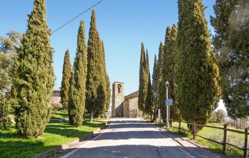 a road lined with trees in front of a church at Nice Home In Pratovecchio Stia in Borgo alla Collina