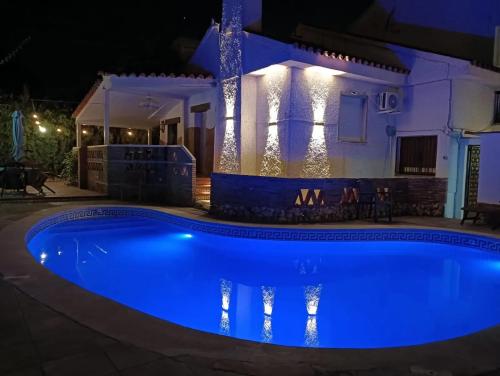 a swimming pool at night in front of a house at Charming Villa in Punta Umbría with Private Pool in Punta Umbría