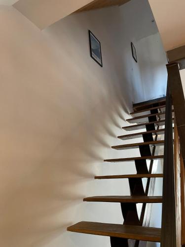 a winding staircase in a house with white walls at Maison Maxime Coeur de ville in Marciac
