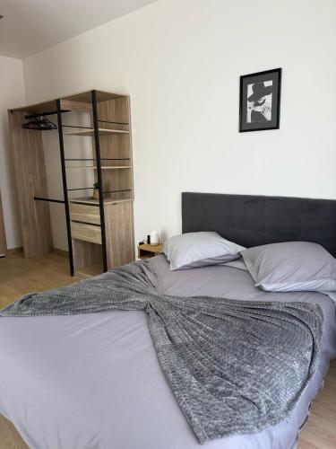 a bed with a blanket on it in a bedroom at EXCEPTIONNEL Studio VERSAILLES in Le Chesnay