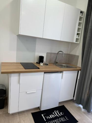 a kitchen with white cabinets and a sink at EXCEPTIONNEL Studio VERSAILLES in Le Chesnay