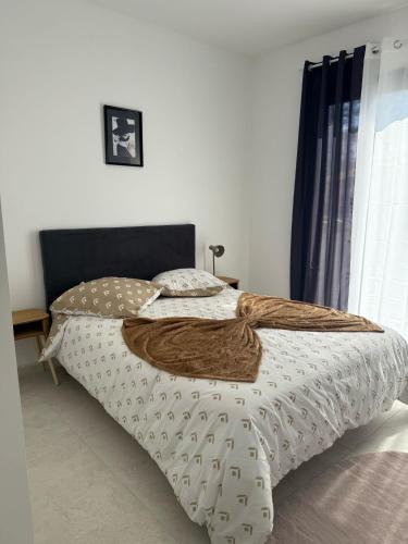 a bedroom with a bed with a brown blanket at EXCEPTIONNEL Studio VERSAILLES in Le Chesnay