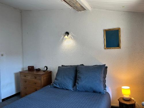 une chambre avec un lit avec des draps bleus et une commode dans l'établissement Maison cosy en Provence Proche Golf Pont Royal, à Alleins