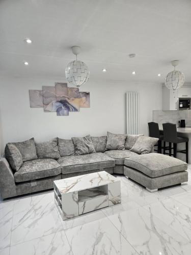 a living room with a couch and a table at A stylish 3 bedroom house or Apartment in Greenhithe - Available for booking as individual Room or as a Whole apartment - 11mins walk to Greenhithe Train Station, 7 mins drive to Bluewater shopping mall in Greenhithe