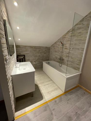 a bathroom with a white tub and a sink at Maison Maxime Coeur de ville in Marciac