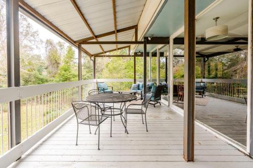 a patio with a table and chairs on a deck at Glass House retreat on scenic Bogue Falaya river in Covington